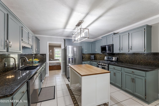 806 Falkirk Ct, Orange Park, FL 32073 - kitchen featuring appliances with stainless steel finishes, wood counters, a sink, light tile patterned flooring, and crown molding