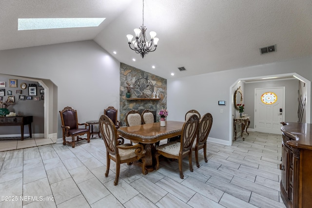 806 Falkirk Ct, Orange Park, FL 32073 - dining room featuring vaulted ceiling, a skylight, arched walkways, a chandelier, and a textured ceiling