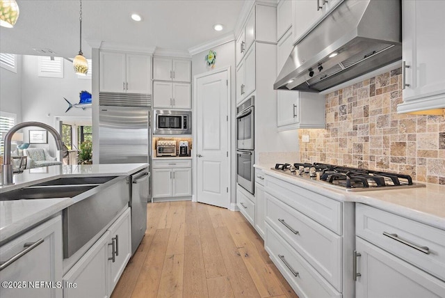 433 Marsh Cove Dr, Ponte Vedra Beach, FL 32082 - kitchen with extractor fan, built in appliances, white cabinetry, a sink, and hanging light fixtures