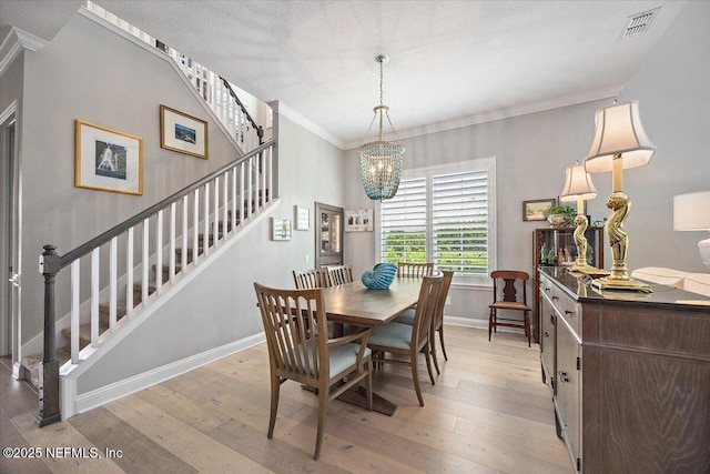 433 Marsh Cove Dr, Ponte Vedra Beach, FL 32082 - dining area featuring stairway, a chandelier, crown molding, light wood-style floors, and baseboards