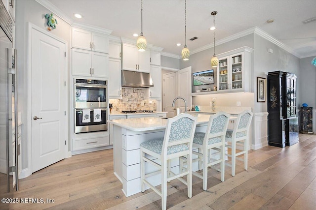 433 Marsh Cove Dr, Ponte Vedra Beach, FL 32082 - kitchen with stainless steel double oven, under cabinet range hood, a sink, light wood-type flooring, and ornamental molding