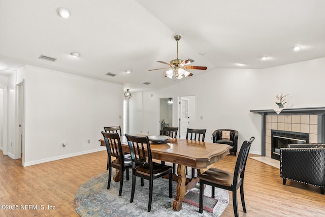 120 Stokes Landing Rd, Saint Augustine, FL 32095 - dining room with ceiling fan, light wood-type flooring, vaulted ceiling, a tiled fireplace, and baseboards