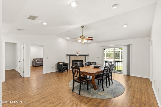 120 Stokes Landing Rd, Saint Augustine, FL 32095 - dining space with vaulted ceiling, a tile fireplace, a ceiling fan, light wood-type flooring, and baseboards