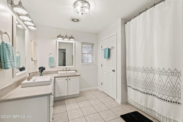 120 Stokes Landing Rd, Saint Augustine, FL 32095 - full bath with tile patterned flooring, two vanities, a textured ceiling, baseboards, and a shower with curtain