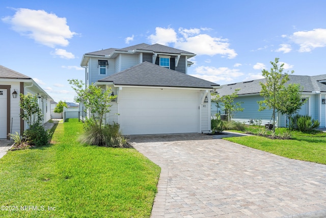 traditional-style home with roof with shingles, a front lawn, decorative driveway, and a garage