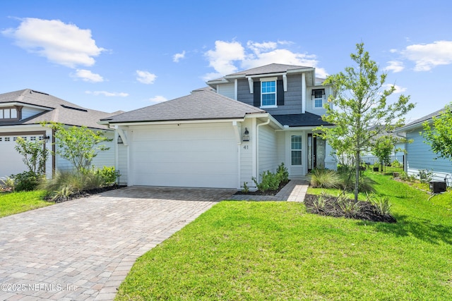 traditional home featuring an attached garage, roof with shingles, and decorative driveway
