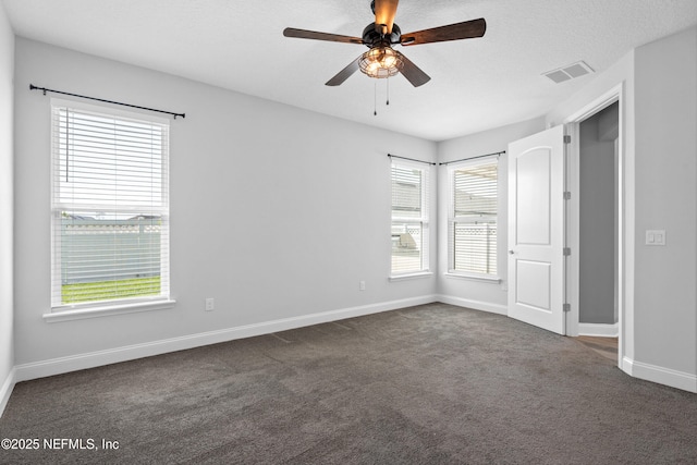 unfurnished bedroom with dark colored carpet, baseboards, and ceiling fan