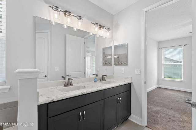 bathroom featuring double vanity and baseboards