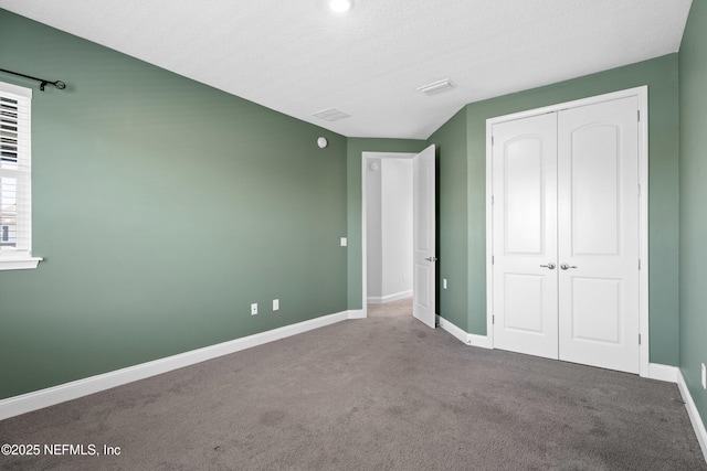 unfurnished bedroom featuring baseboards, carpet floors, and a closet