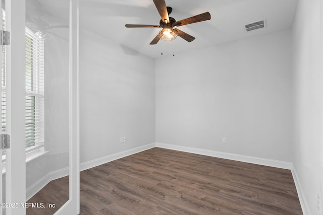 unfurnished room with ceiling fan, healthy amount of natural light, wood finished floors, and baseboards