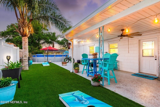view of yard with a patio area, a pool, and a ceiling fan