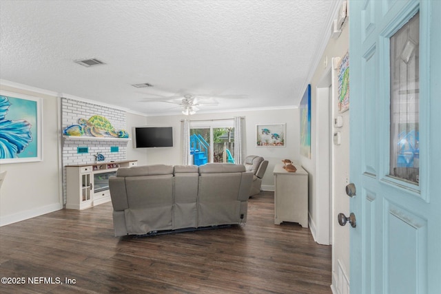 living room with dark wood-style floors, crown molding, a textured ceiling, ceiling fan, and baseboards