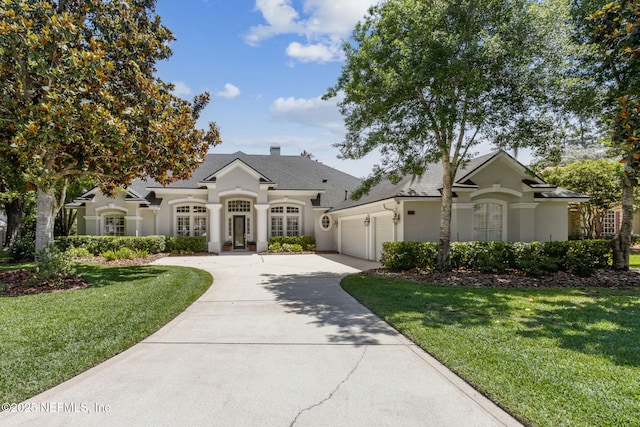 724 Piney Pl, Saint Johns, FL 32259 - french country style house with stucco siding, a garage, concrete driveway, a front yard, and a shingled roof