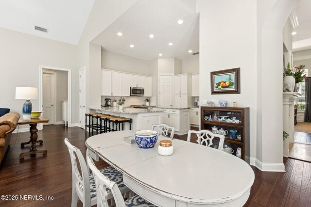 724 Piney Pl, Saint Johns, FL 32259 - dining area featuring baseboards, dark wood-type flooring, a high ceiling, recessed lighting, and arched walkways