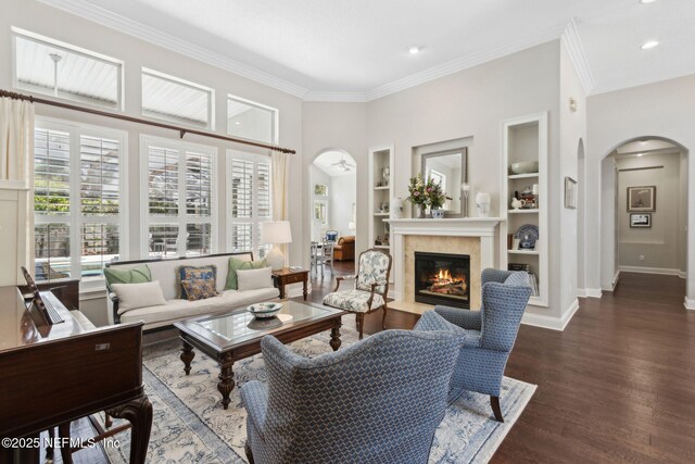 724 Piney Pl, Saint Johns, FL 32259 - living area featuring arched walkways, built in shelves, a fireplace with flush hearth, baseboards, and wood finished floors