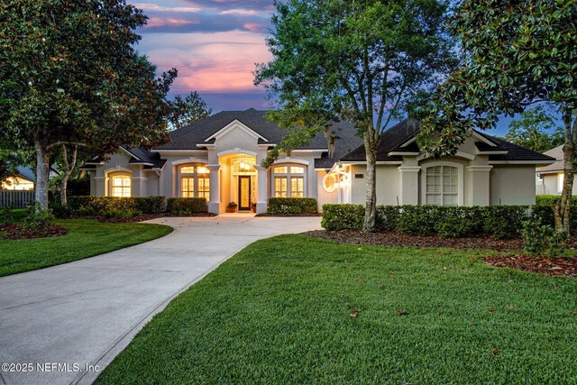 724 Piney Pl, Saint Johns, FL 32259 - view of front of home featuring stucco siding, concrete driveway, a front lawn, and a shingled roof
