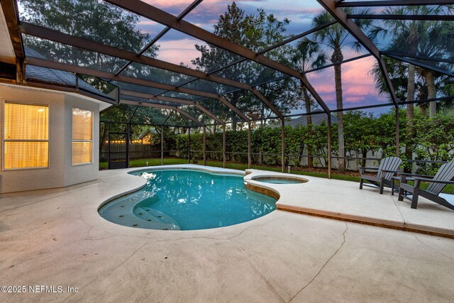 724 Piney Pl, Saint Johns, FL 32259 - pool at dusk featuring a patio, a fenced backyard, a pool with connected hot tub, and glass enclosure