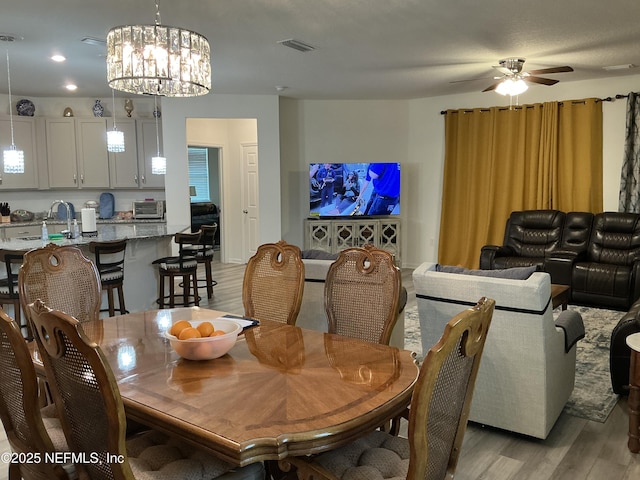 10470 Collins Field Cir, Jacksonville, FL 32222 - dining room with light wood finished floors, a ceiling fan, a chandelier, and recessed lighting