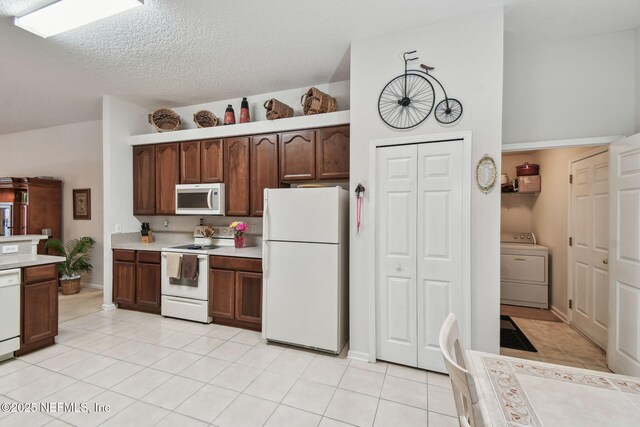 324 Hammock Grove Ct, Saint Johns, FL 32259 - kitchen with white appliances, washer / dryer, light countertops, light tile patterned floors, and a textured ceiling