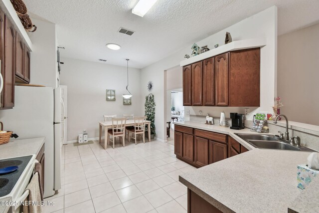 324 Hammock Grove Ct, Saint Johns, FL 32259 - kitchen with a sink, light tile patterned flooring, light countertops, a textured ceiling, and pendant lighting