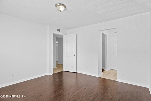 6552 La Mirada Dr E Unit 7, Jacksonville, FL 32217 - empty room featuring wood finished floors, a textured ceiling, and baseboards