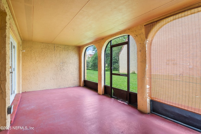 6552 La Mirada Dr E Unit 7, Jacksonville, FL 32217 - unfurnished sunroom with a textured wall and finished concrete flooring