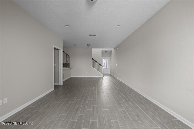 698 Cherry Elm Dr, Saint Augustine, FL 32092 - unfurnished living room with stairway, wood finished floors, baseboards, and a textured ceiling