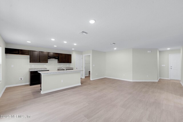 5420 Arlington Rd, Jacksonville, FL 32211 - kitchen with a kitchen island with sink, light wood-style flooring, baseboards, dark brown cabinetry, and recessed lighting