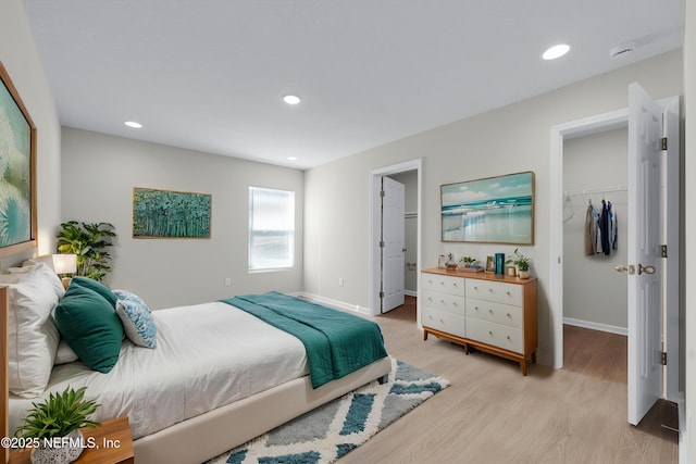 5420 Arlington Rd, Jacksonville, FL 32211 - bedroom with a spacious closet, light wood finished floors, a closet, baseboards, and recessed lighting