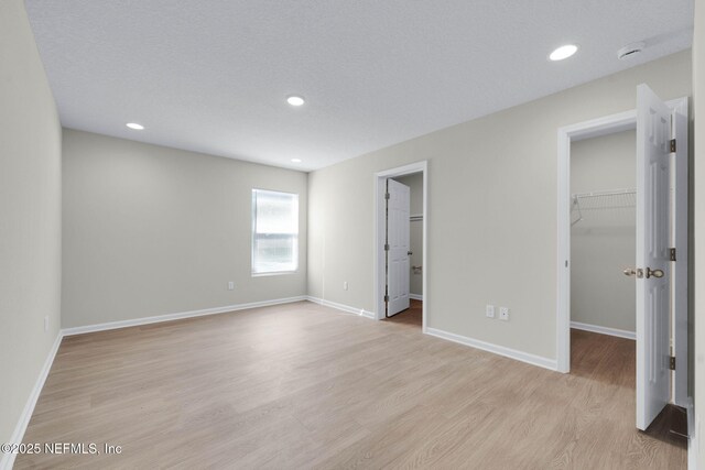 5420 Arlington Rd, Jacksonville, FL 32211 - unfurnished bedroom featuring a walk in closet, light wood finished floors, baseboards, recessed lighting, and a closet