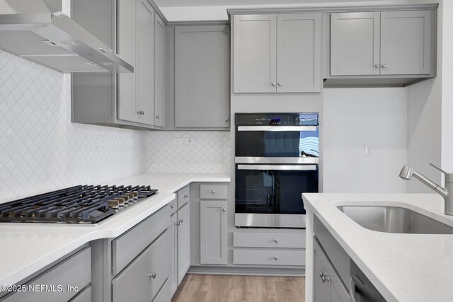 478 Cherry Elm Dr, Saint Augustine, FL 32092 - kitchen with gray cabinetry, stainless steel appliances, a sink, extractor fan, and light wood finished floors