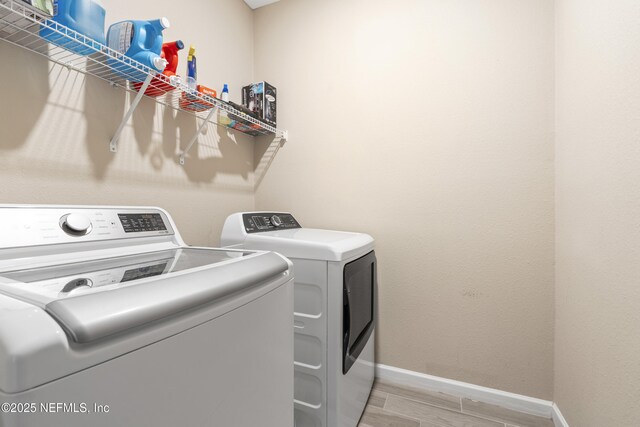 383 Saint Vincent Dr, Saint Augustine, FL 32092 - clothes washing area with baseboards, washer and dryer, and light wood-style flooring