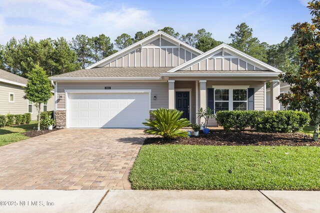 383 Saint Vincent Dr, Saint Augustine, FL 32092 - view of front of house featuring board and batten siding, decorative driveway, a garage, and a front yard