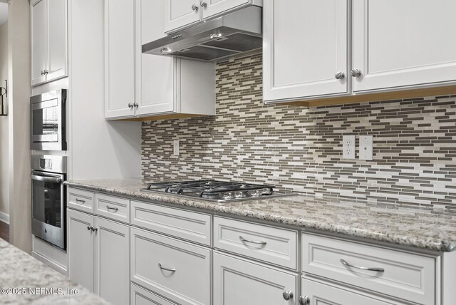 14048 Prater Ct, Jacksonville, FL 32224 - kitchen featuring under cabinet range hood, appliances with stainless steel finishes, tasteful backsplash, and white cabinetry