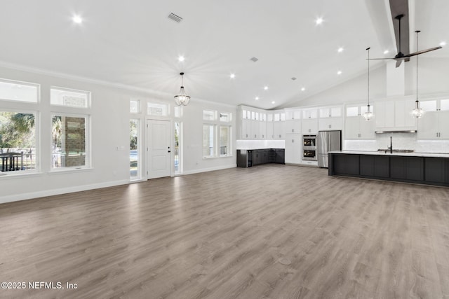97002 Jose Gaspar Way, Yulee, FL 32097 - unfurnished living room featuring high vaulted ceiling, light wood-style flooring, baseboards, recessed lighting, and a chandelier