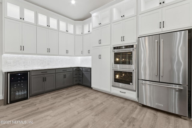 97002 Jose Gaspar Way, Yulee, FL 32097 - kitchen featuring appliances with stainless steel finishes, beverage cooler, gray cabinetry, light wood-style floors, and white cabinetry