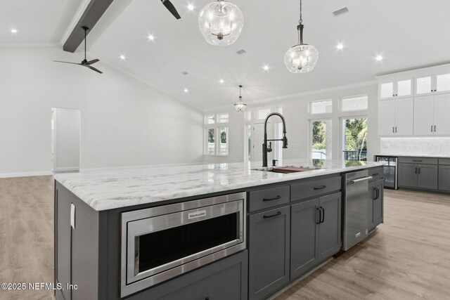 97002 Jose Gaspar Way, Yulee, FL 32097 - kitchen with stainless steel appliances, a sink, gray cabinets, a large island, and light wood finished floors