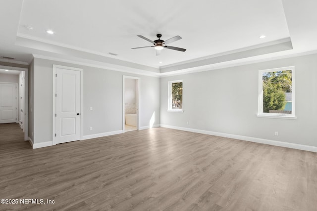 97002 Jose Gaspar Way, Yulee, FL 32097 - unfurnished bedroom with a raised ceiling, ornamental molding, multiple windows, baseboards, and wood finished floors