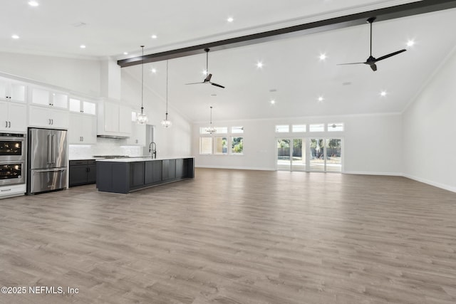 97002 Jose Gaspar Way, Yulee, FL 32097 - unfurnished living room featuring ceiling fan, high vaulted ceiling, a sink, baseboards, and a chandelier