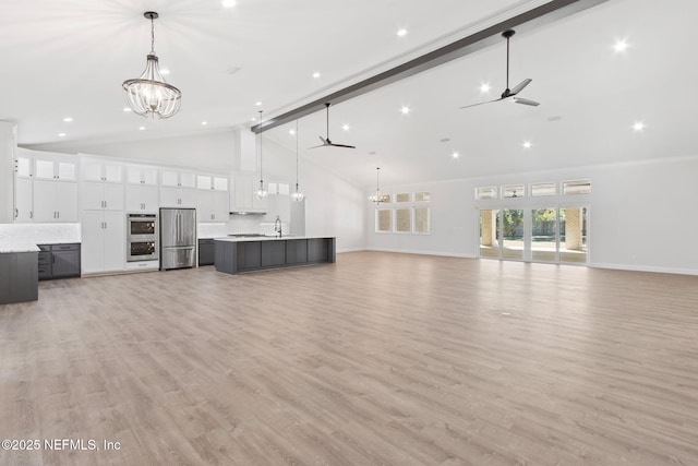 97002 Jose Gaspar Way, Yulee, FL 32097 - unfurnished living room featuring ceiling fan, a chandelier, high vaulted ceiling, a sink, and baseboards