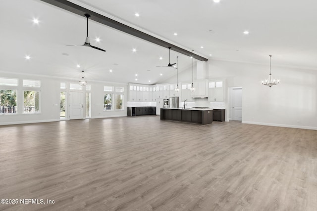 97002 Jose Gaspar Way, Yulee, FL 32097 - unfurnished living room featuring a chandelier, beamed ceiling, a ceiling fan, baseboards, and a sink