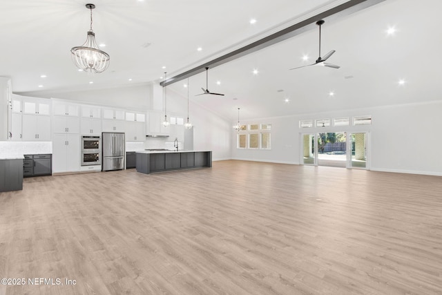 97002 Jose Gaspar Way, Yulee, FL 32097 - unfurnished living room featuring a chandelier, ceiling fan, high vaulted ceiling, baseboards, and light wood finished floors