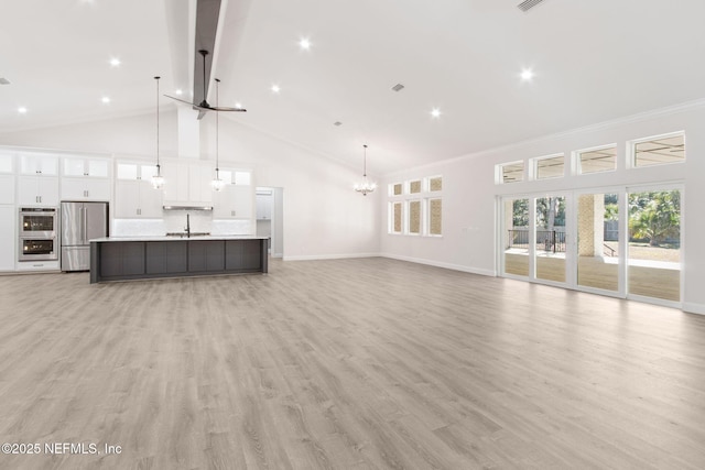 97002 Jose Gaspar Way, Yulee, FL 32097 - unfurnished living room with high vaulted ceiling, a sink, baseboards, a chandelier, and light wood-style flooring