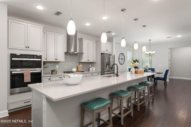275 Kellet Way, Saint Johns, FL 32259 - kitchen with wall chimney range hood, appliances with stainless steel finishes, dark wood-style floors, a large island with sink, and decorative backsplash