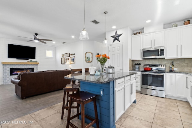 219 Heron Landing Rd, Saint Johns, FL 32259 - kitchen featuring stainless steel appliances, ceiling fan, a breakfast bar, dark stone counters, and recessed lighting