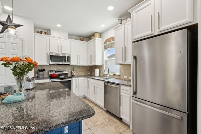 219 Heron Landing Rd, Saint Johns, FL 32259 - kitchen featuring stainless steel appliances, a sink, white cabinetry, tasteful backsplash, and light tile patterned floors