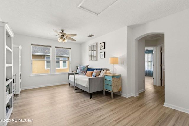 219 Heron Landing Rd, Saint Johns, FL 32259 - living area featuring light wood-style flooring, arched walkways, healthy amount of natural light, a textured ceiling, and a ceiling fan