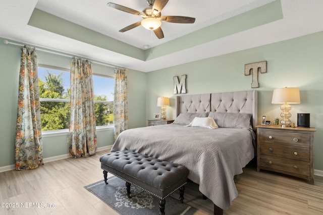 219 Heron Landing Rd, Saint Johns, FL 32259 - bedroom featuring a tray ceiling, baseboards, wood finished floors, and ceiling fan