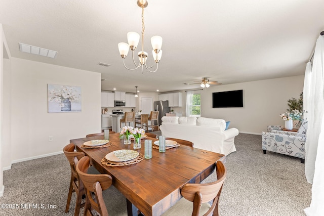 dining area featuring a chandelier, light colored carpet, baseboards, and ceiling fan