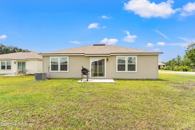 rear view of house with a patio area, a lawn, stucco siding, and central air condition unit